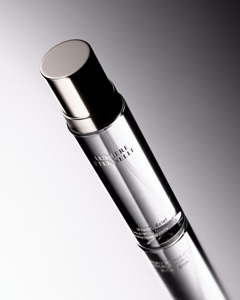 Clear glass cosmetic mist bottle representing setting spray